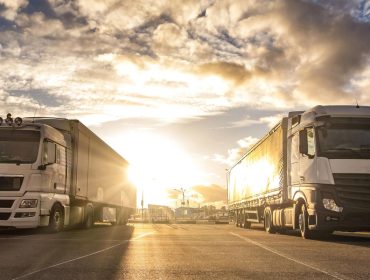 caminhoes-seguidos-com-conteineres-no-conceito-de-logistica-e-transporte-de-estacionamento-1